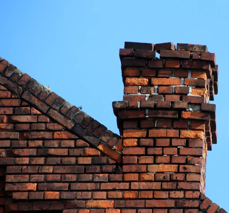 Damaged chimney on an Bloomfield Hills home showing cracks and missing mortar